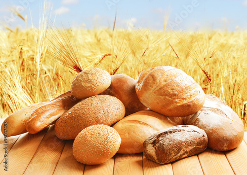 Fényképezés Fresh bread on wheat field background