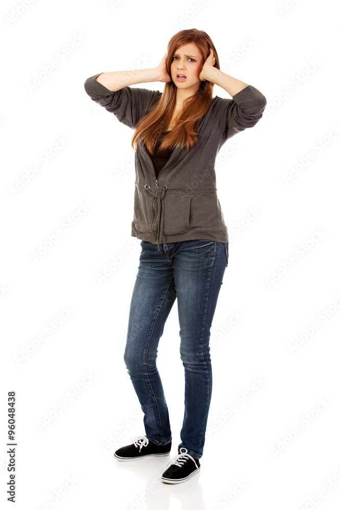 Angry teenage woman covering ears with hands Angry teenage woman covering ears with hands