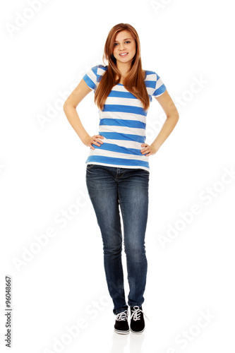Smiling teenage woman with hands on hips