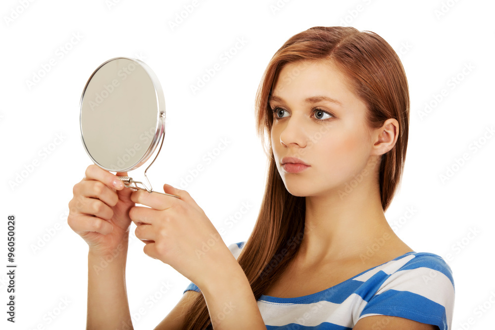 Young beautiful woman looking in a mirror Young beautiful woman looking in a mirror