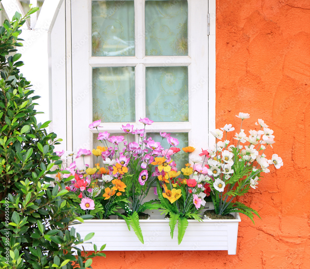 Fototapeta premium Flower box in window of orange building