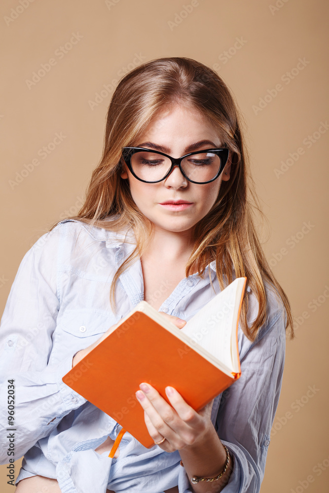 Girl with glasses holds a notebook. Girl with glasses holds a notebook.