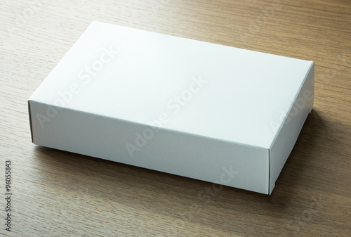 blank white paper box on dark wood background © aopsan