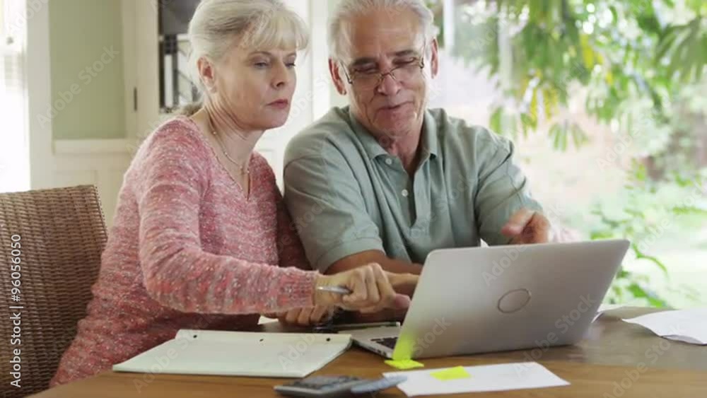 Sweet Senior couple using laptop computer to pay bills Sweet Senior couple using laptop computer to pay bills