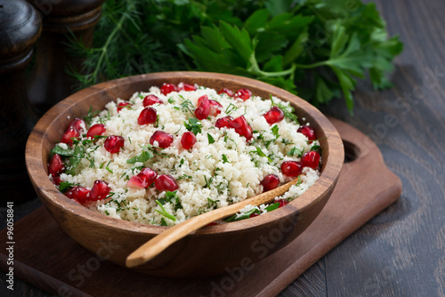 Cauliflower couscous with herbs and pomegranate on wooden table