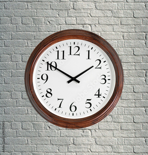 Wall clock with wooden frame on brick grey wall