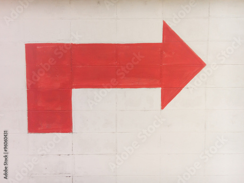 Red arrow turn right sign on concrete wall
