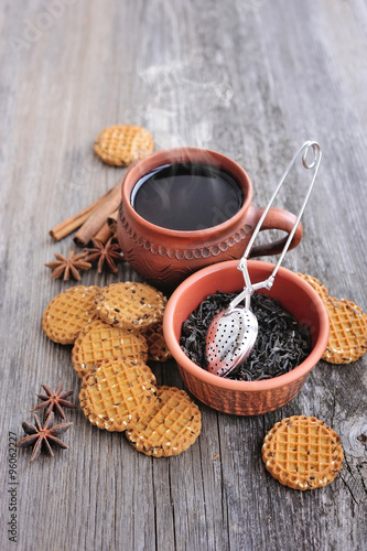 Fototapeta Naklejka Na Ścianę i Meble -  A cup of hot tea with cookies on a rustic wooden background