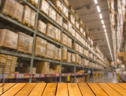 Abstract blurred boxes on rows of shelves in big modern warehous