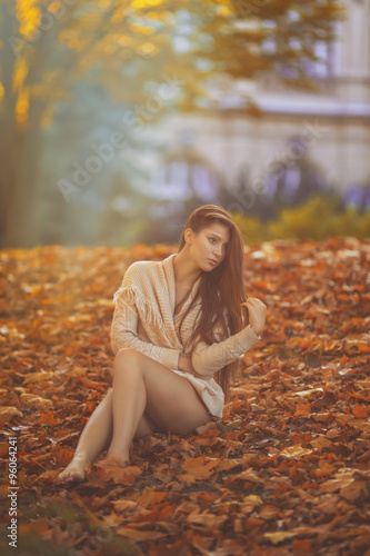 Outdoor photo from a beautiful young women sitting in a castle garden at autumn