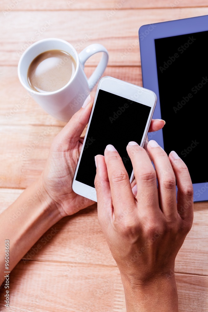 Businesswoman using her smartphone on desk Businesswoman using her smartphone on desk