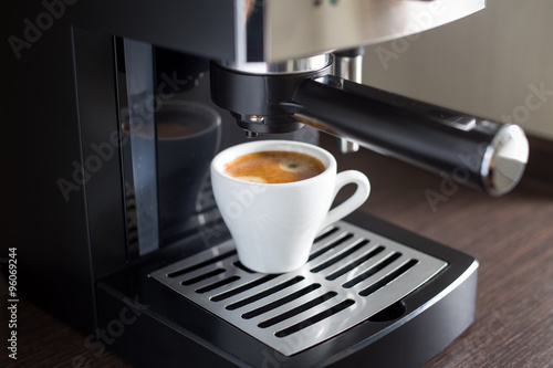White ceramic cup of espresso with coffee machine