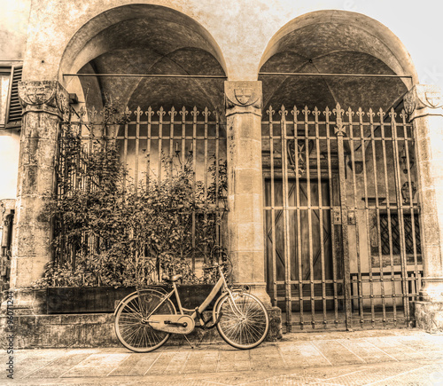 old bicycle parked by a beautiful loggia in sepia tone © Gabriele Maltinti