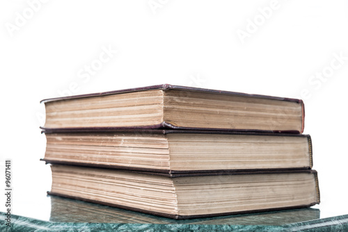 Three old books on green marble table