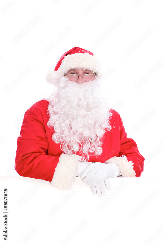 Kind Santa Claus looking out from behind the blank sign isolated on white background with copy space Kind Santa Claus looking out from behind the blank sign isolated on white background with copy space