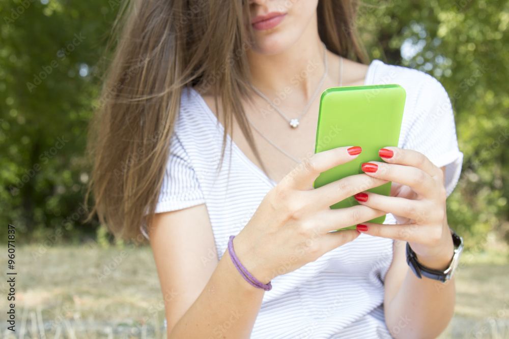 Young woman using cellphone outdoors. Young woman using cellphone outdoors.