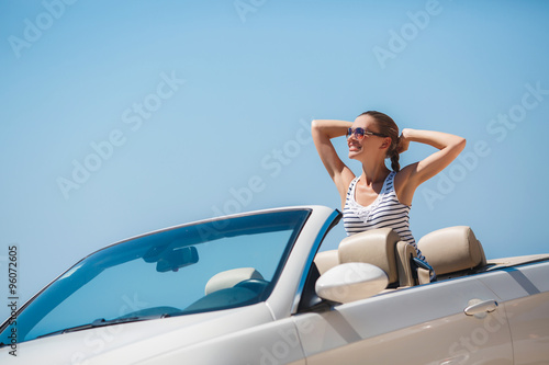 Beautiful woman in a white convertible car. © GTeam