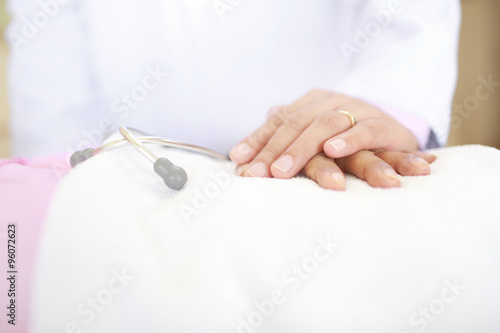 Hand of doctor comforting female patient.