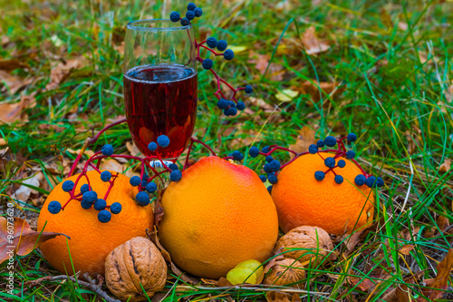 closeup wineglass with fruirs in a grass photo