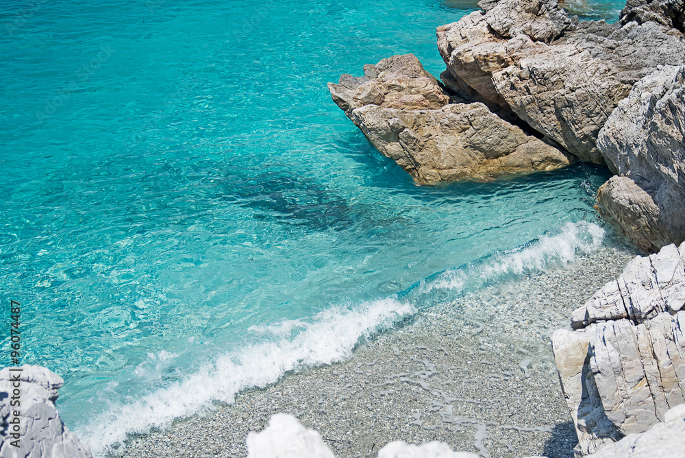 Clear Turquoise Sea Water, Stones and Wave. Greece.
