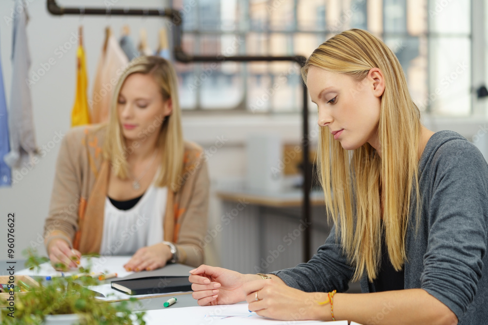 zwei junge frauen arbeiten in einem atelier für modedesign zwei junge frauen arbeiten in einem atelier für modedesign