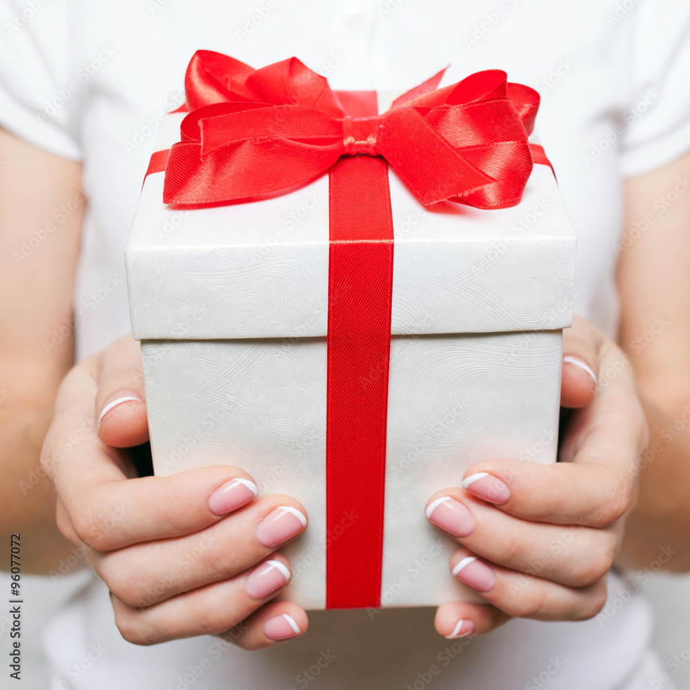 Female hand holding a gift box Female hand holding a gift box