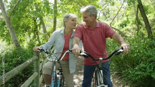 Happy senior couple laughing having a good time on bikes