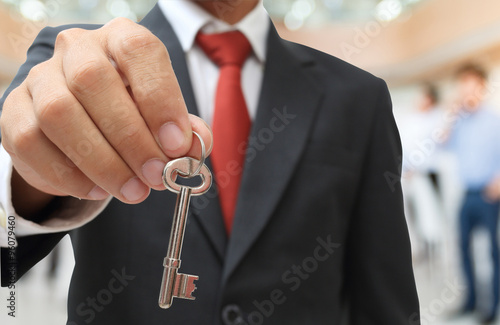 businessman showing the silver key to success