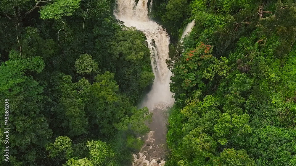 Amazing Powerful Waterfall in Tropical Jungle. Slow Motion Aerial View Flying Over Rushing Waterfall in Rain Forest. Amazing Powerful Waterfall in Tropical Jungle. Slow Motion Aerial View Flying Over Rushing Waterfall in Rain Forest.