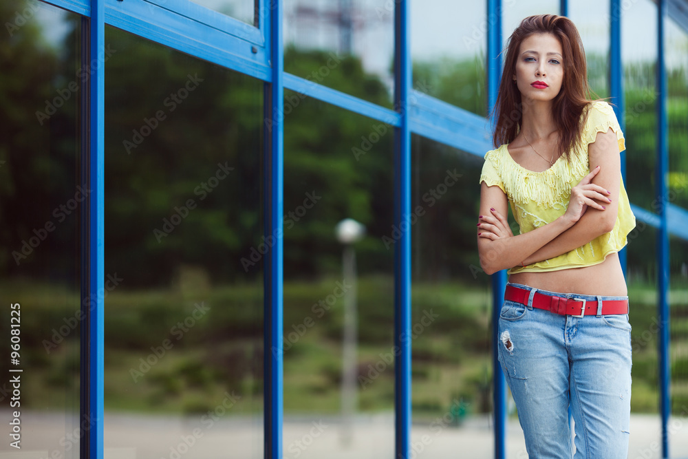 Gorgeous hipster girl in blue jeans in the summer city.