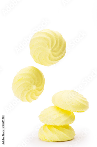 yellow meringues flying on white background