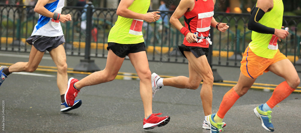 marathon runners running on city road marathon runners running on city road