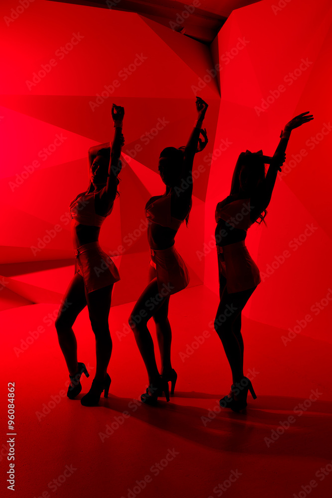 Silhouettes of three sexy posing girls