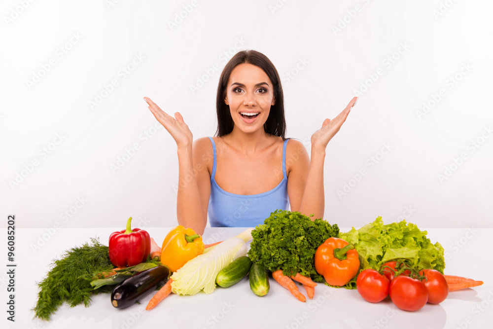 Surprised beautiful girl on a diet with vegetables on the table Surprised beautiful girl on a diet with vegetables on the table
