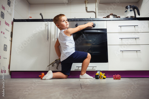 child playing in the kitchen with a gas stove. photo