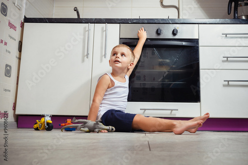 Fotografie child playing in the kitchen with a gas stove.
