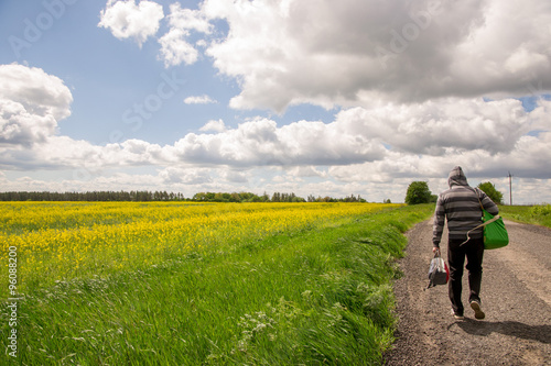 a man follows a road in the field © InessaI