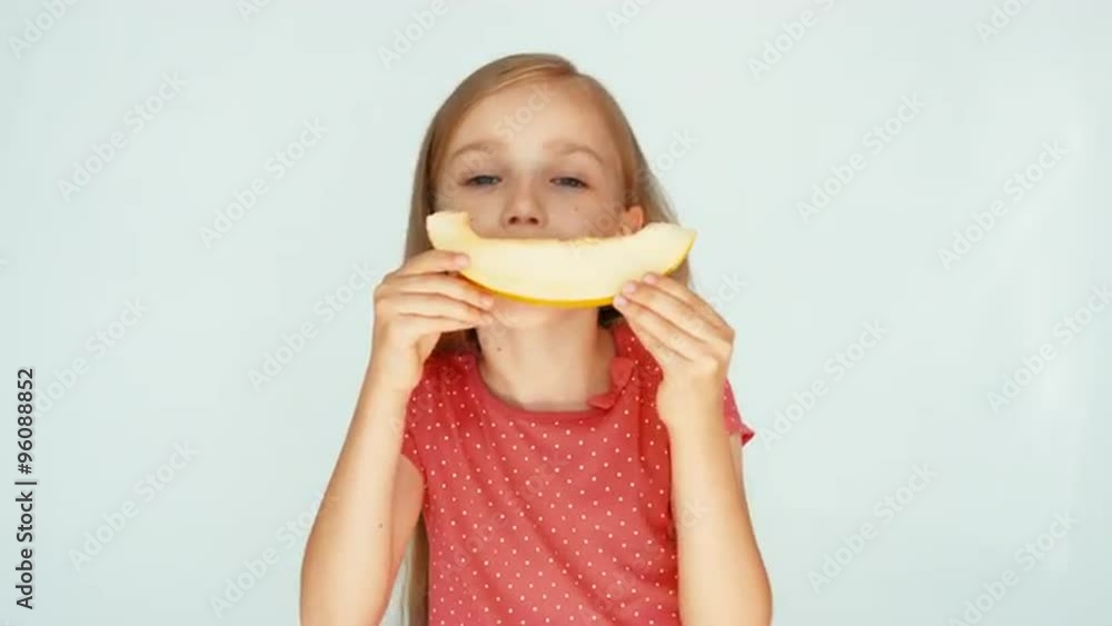 Girl sniffing yellow melon on the white background. Very tasty melon Girl sniffing yellow melon on the white background. Very tasty melon