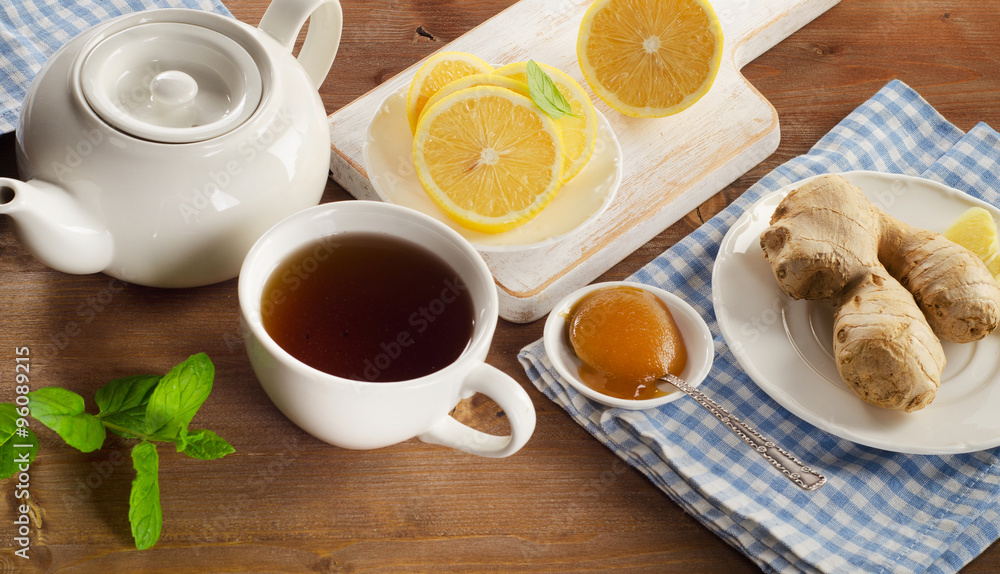 Teapot and cup of tea with lemon, ginger, honey and mint Teapot and cup of tea with lemon, ginger, honey and mint