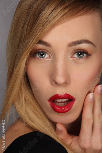 portrait of blond young woman with make up and red lips.