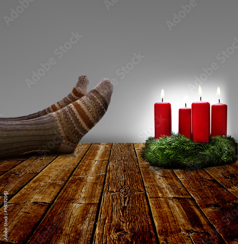Füße auf dem Tisch mit Adventskranz