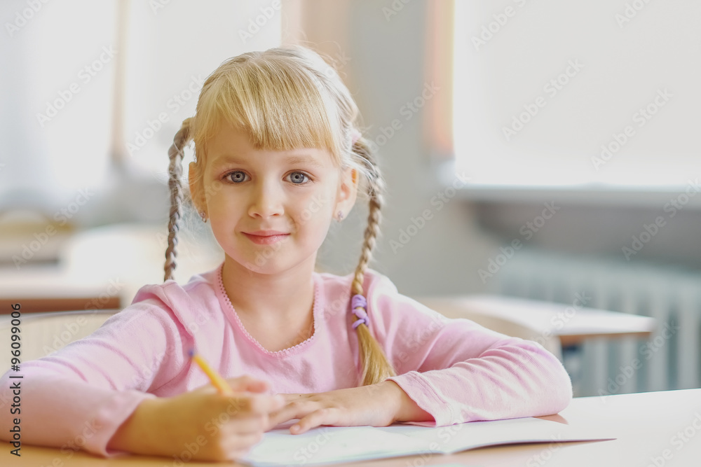 five years old blonde girl sitting at classroom and writing five years old blonde girl sitting at classroom and writing