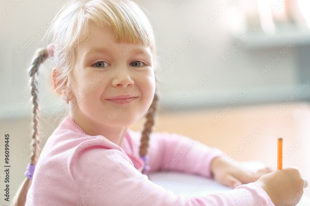 Cute five years old blonde girl sitting at classroom Cute five years old blonde girl sitting at classroom