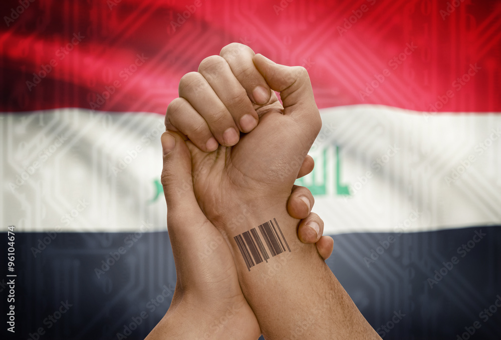Barcode ID number on wrist of dark skinned person and national flag on background - Iraq
