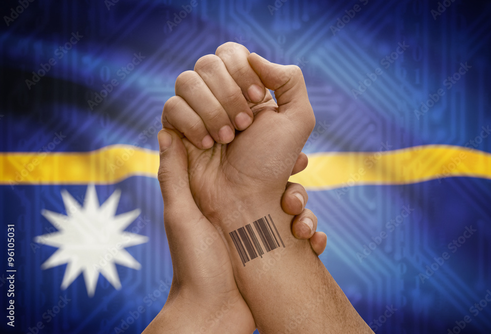 Barcode ID number on wrist of dark skinned person and national flag on background - Nauru