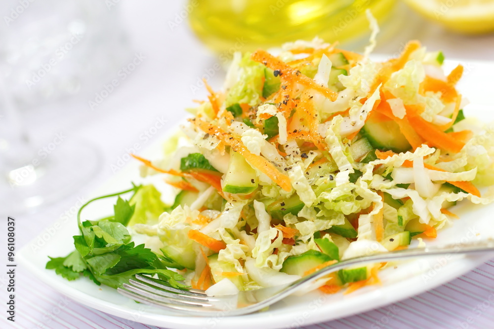 Salad made of fresh cucumbers, cabbage and carrots Salad made of fresh cucumbers, cabbage and carrots