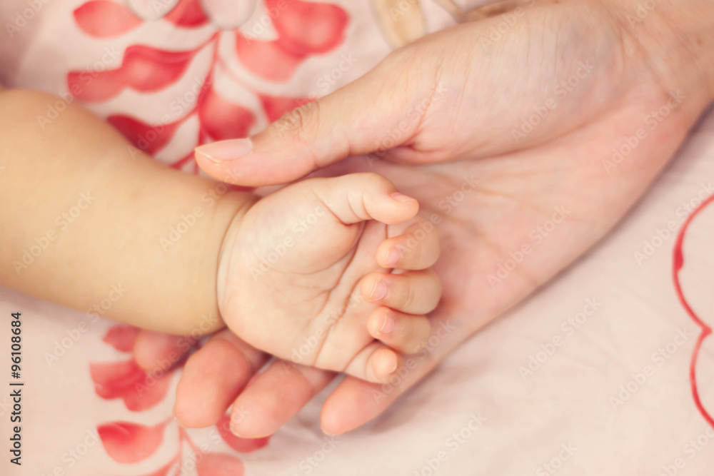 blur background hand mother touch the hand her baby. blur background hand mother touch the hand her baby.