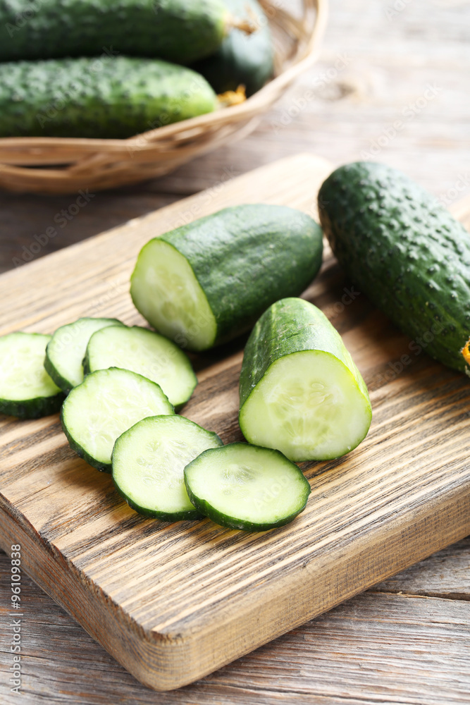 Fresh cucumbers on cutting board on grey wooden background Fresh cucumbers on cutting board on grey wooden background