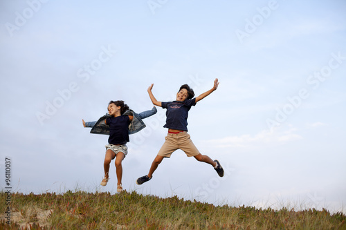 Niño y niña saltando alegres