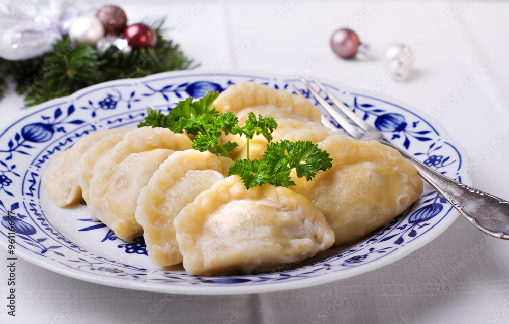 Polish dumplings on a white plate with blue Christmas decoration Polish dumplings on a white plate with blue Christmas decoration